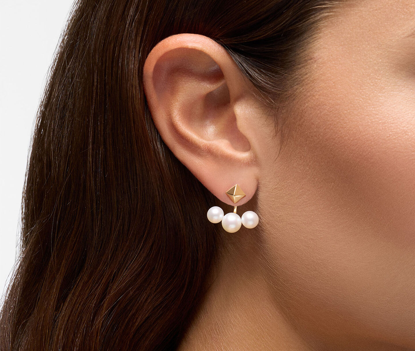 A woman wearing Birks Rock and Pearl yellow gold and pearl jacket earrings.